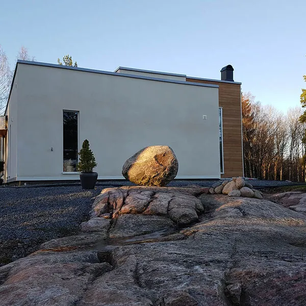 Vitt modernt hus med fasta aluminiumfönster på en berghäll