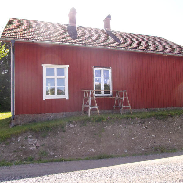 Vita öppningsbara tvåluftsfönster på ett rött hus