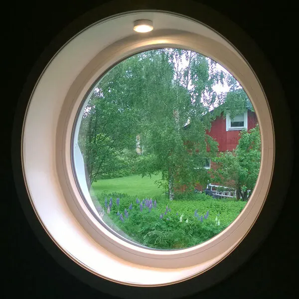 Runt fast fönster sett från insidan med utsikt över grönska