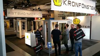 Kronfönsters mässmonter på Nordbygg i Stockholm med fönster och besökare