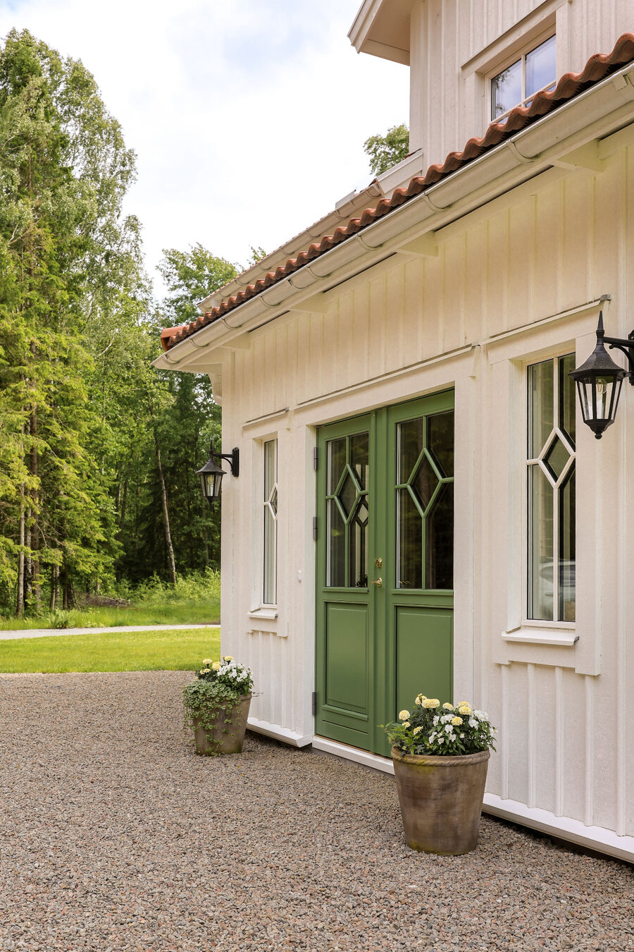Grön pardörr i trä med diamantspröjs, modell Sekel, i vit panelfasad