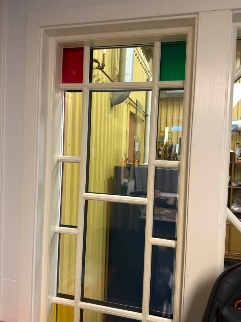 Insida av klassiskt träfönster med spröjs och färgat glas